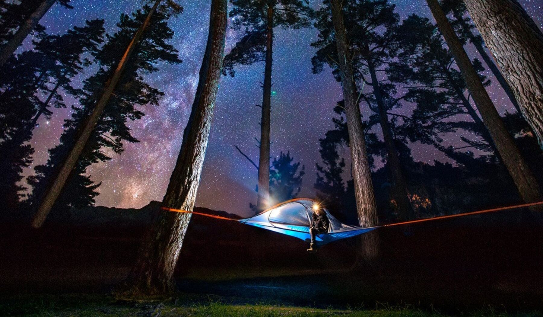Tente suspendue de nuit sous les étoiles